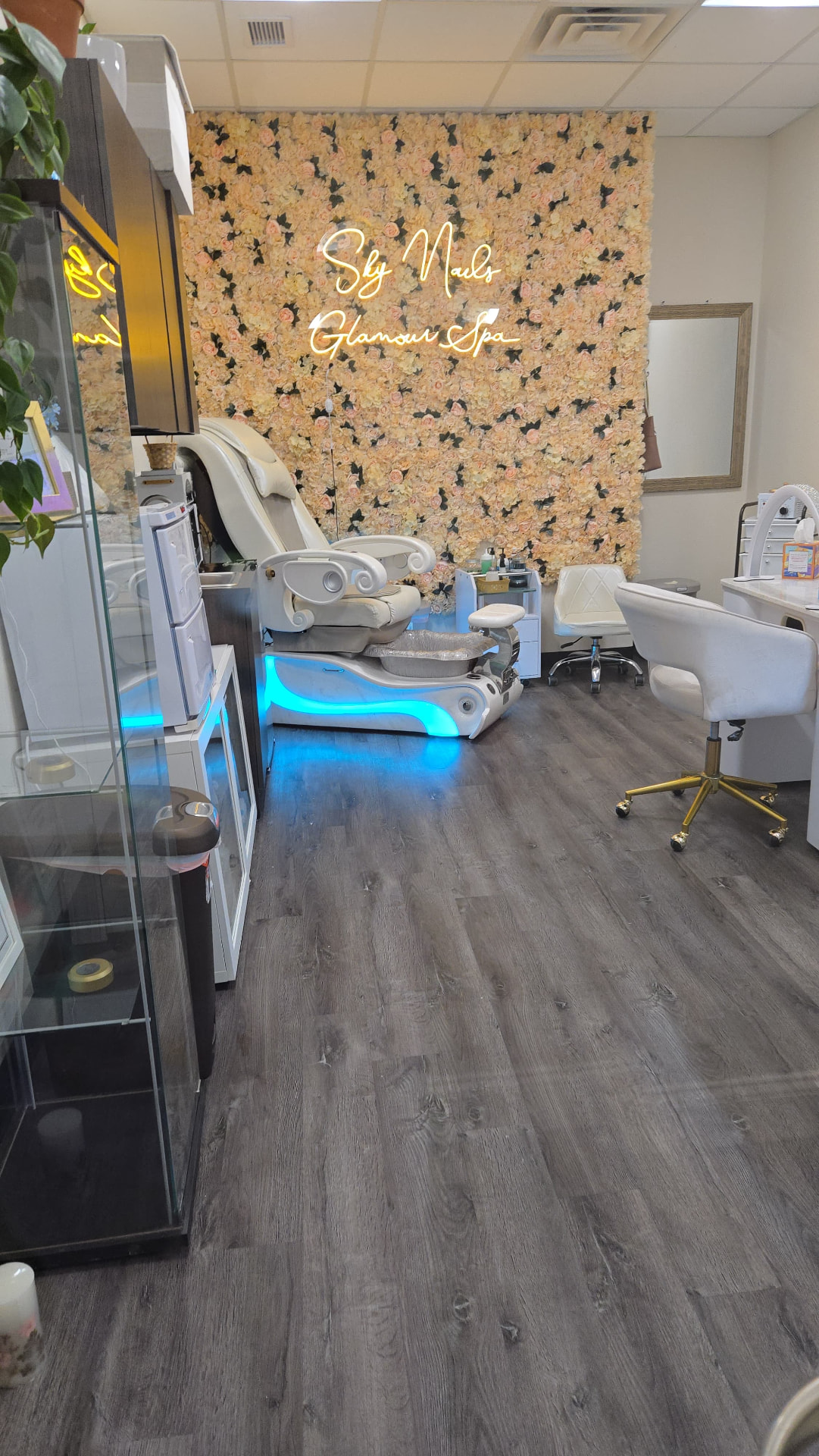 Sky Nails Glamour Spa interior with a floral feature wall, gold neon sign and luxury pedicure chairs