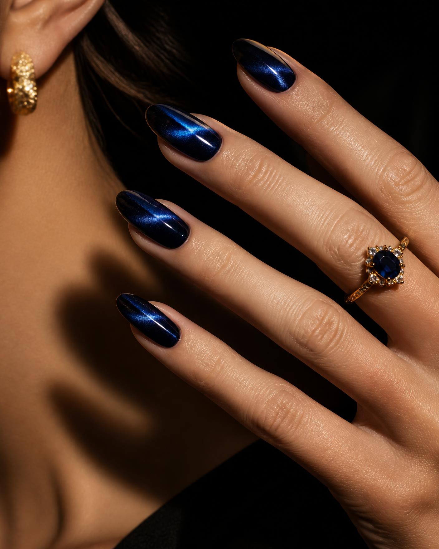 Close-up of glossy midnight blue cat eye gel nails